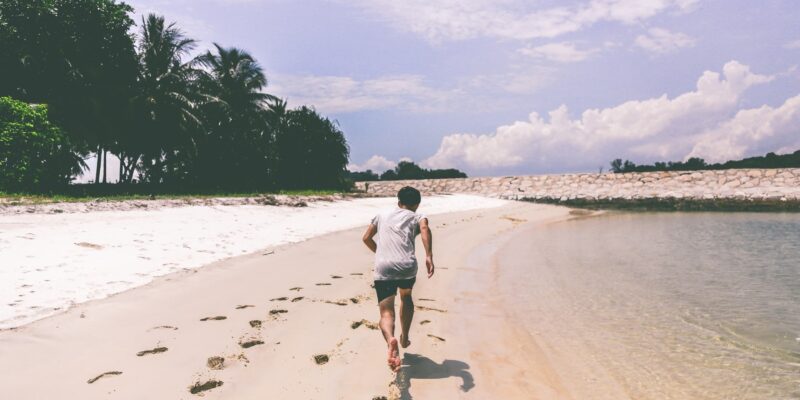 Мужчина бежит по пляжу